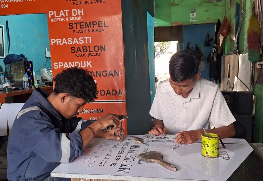Pemilik usaha advertising di Kupang NTT, Henos Efendi Serak, menunjukkan produk advertising hasil usahanya yang berkembang berkat dukungan KUR BRI