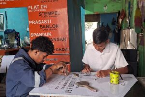 Pemilik usaha advertising di Kupang NTT, Henos Efendi Serak, menunjukkan produk advertising hasil usahanya yang berkembang berkat dukungan KUR BRI