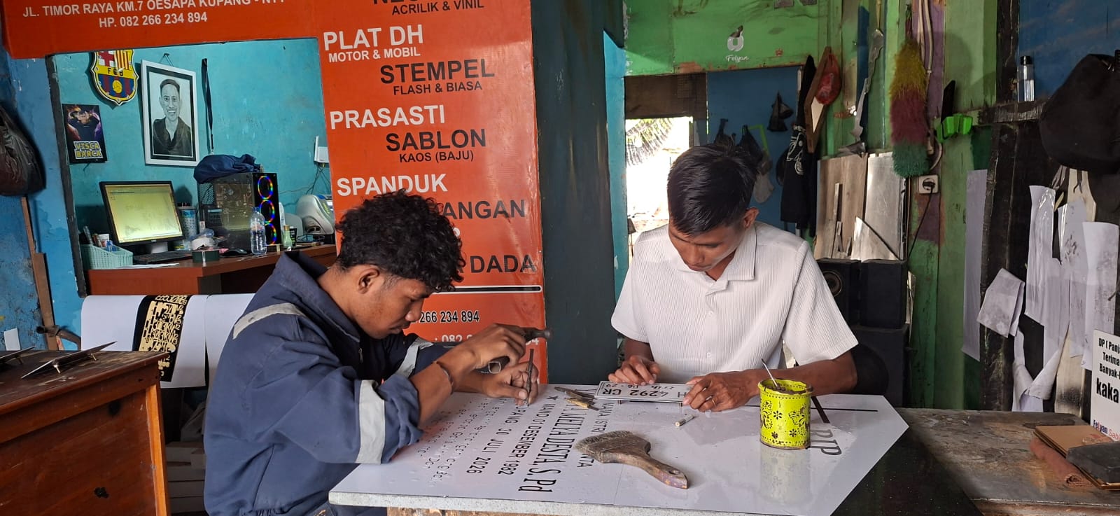 Pemilik usaha advertising di Kupang NTT, Henos Efendi Serak, menunjukkan produk advertising hasil usahanya yang berkembang berkat dukungan KUR BRI