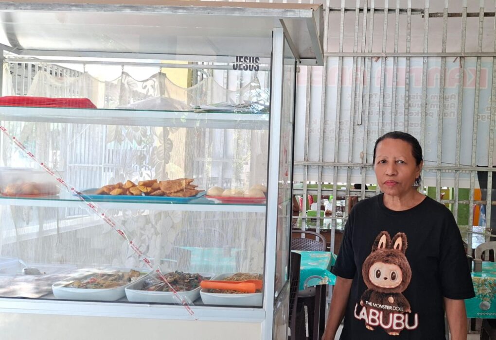 Hana Agsamina Patttypelohi pemilik usaha kantin di Kupang berdiri di depan etalase makanan dengan dukungan KUR BRI