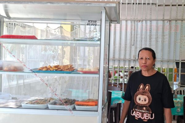 Hana Agsamina Patttypelohi pemilik usaha kantin di Kupang berdiri di depan etalase makanan dengan dukungan KUR BRI
